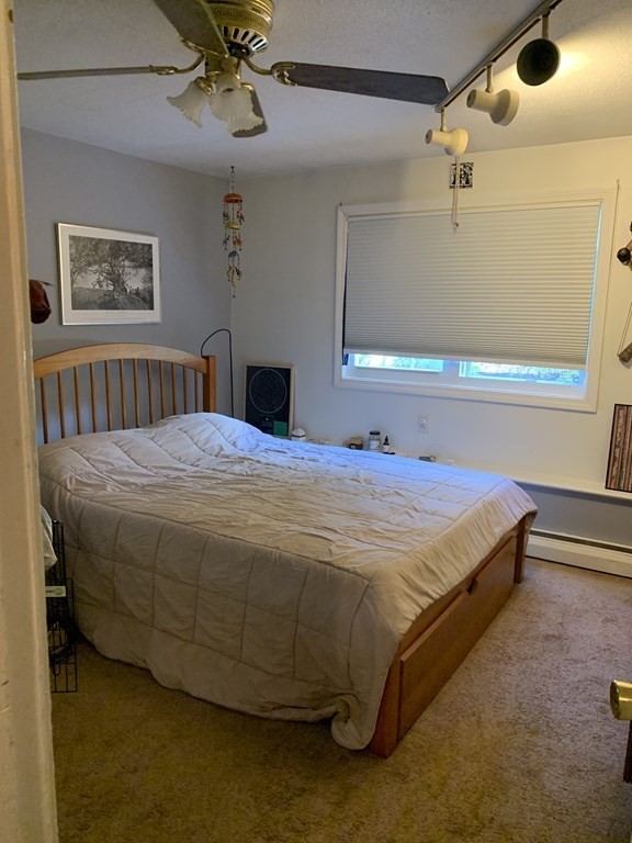 424 Great Road, Unit 2 Acton, MA 01720 - Photo 5 of 13 a bedroom with a bed and a chandelier