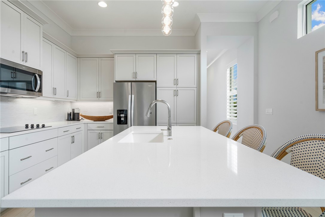 2159 Falls Manor Vero Beach, FL 32967 - Photo 12 of 36 a white kitchen with stainless steel appliances a sink a stove and white cabinets