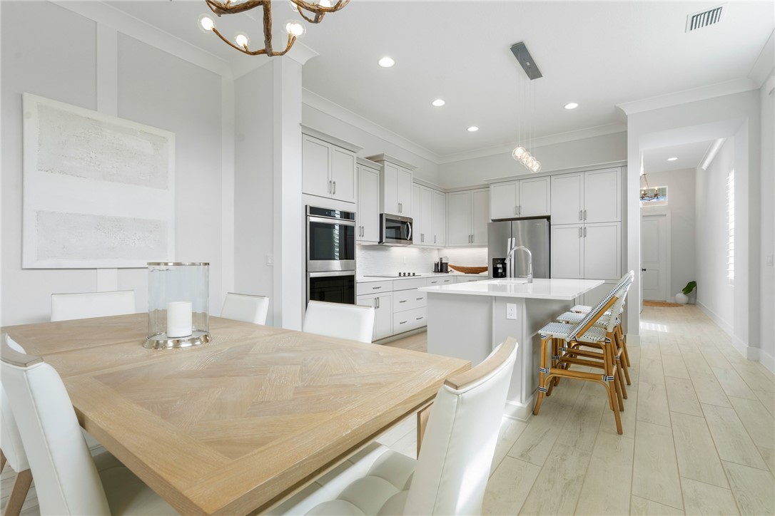 2159 Falls Manor Vero Beach, FL 32967 - Photo 16 of 36 a kitchen with a table chairs refrigerator and cabinets