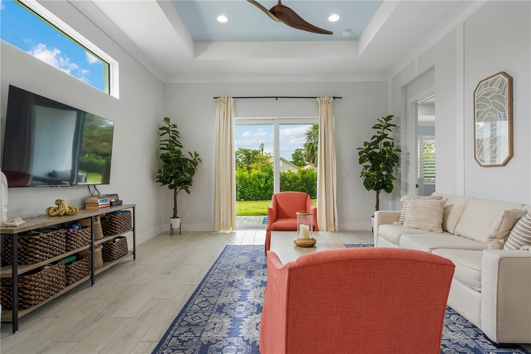 2159 Falls Manor Vero Beach, FL 32967 - Photo 18 of 36 a living room with furniture a flat screen tv and a large window