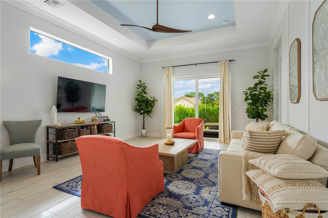 2159 Falls Manor Vero Beach, FL 32967 - Photo 19 of 36 a living room with furniture a flat screen tv and a large window