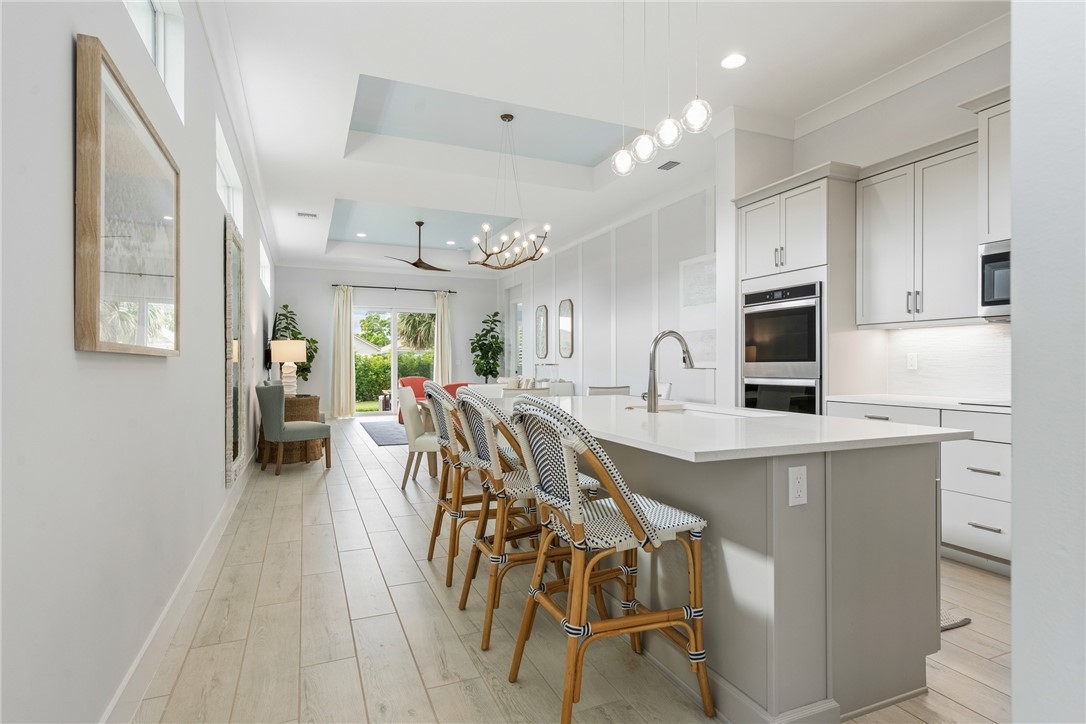 2159 Falls Manor Vero Beach, FL 32967 - Photo 6 of 36 a large kitchen with kitchen island a large counter space a sink appliances and cabinets