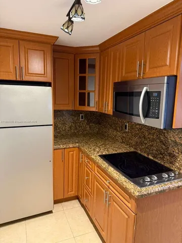 a kitchen with stainless steel appliances granite countertop a sink and a refrigerator