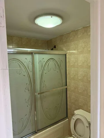 a bathroom with a toilet and a mirror