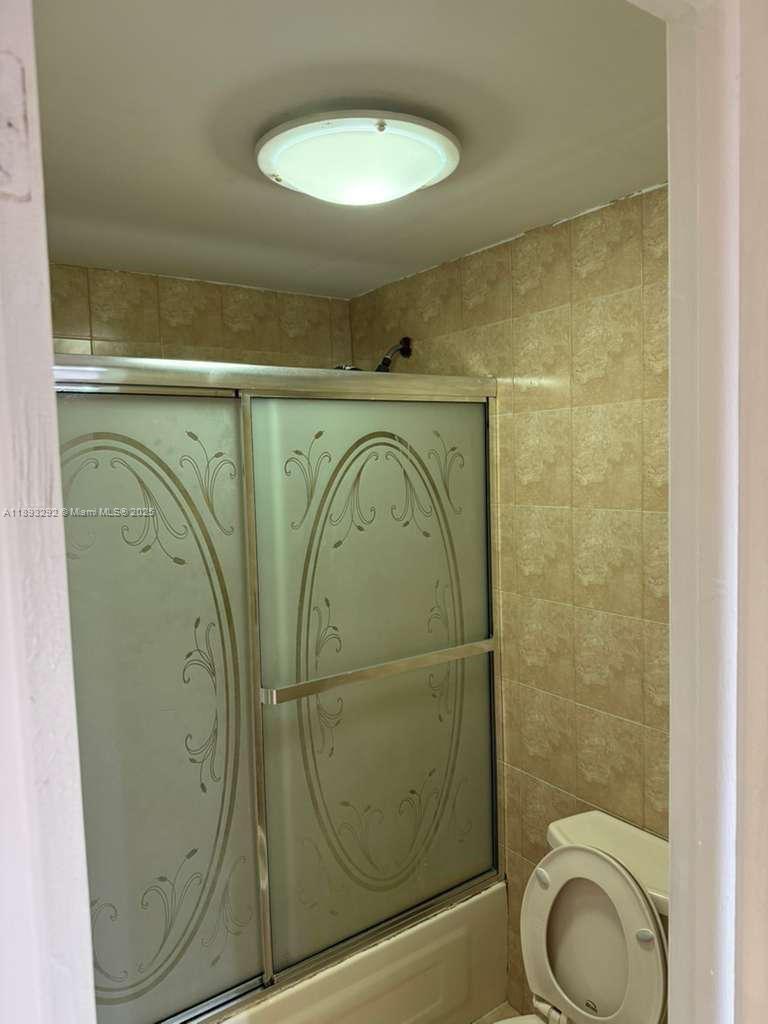 7000 Northwest 186th Street, Unit 4129A Hialeah, FL 33015 - Photo 4 of 7 a bathroom with a toilet and a mirror