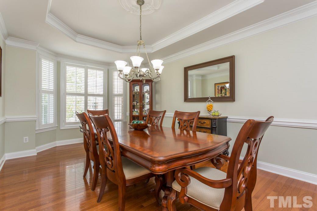 404 Powers Ferry Road Cary, NC 27519 - Photo 3 of 25 Formal dining room with bay and plantation shutters, crown molding on trey ceiling, medallion for light fixture and chair rails highlight the grandeur of this room.