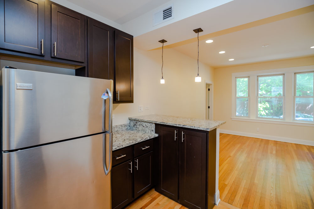 2641 West George Street, Unit 1 Chicago, IL 60618 - Photo 2 of 11 a kitchen with stainless steel appliances granite countertop a refrigerator a sink and a stove top oven