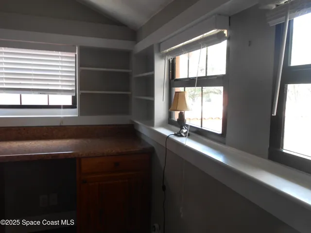 a front view of a house with a yard and potted plants