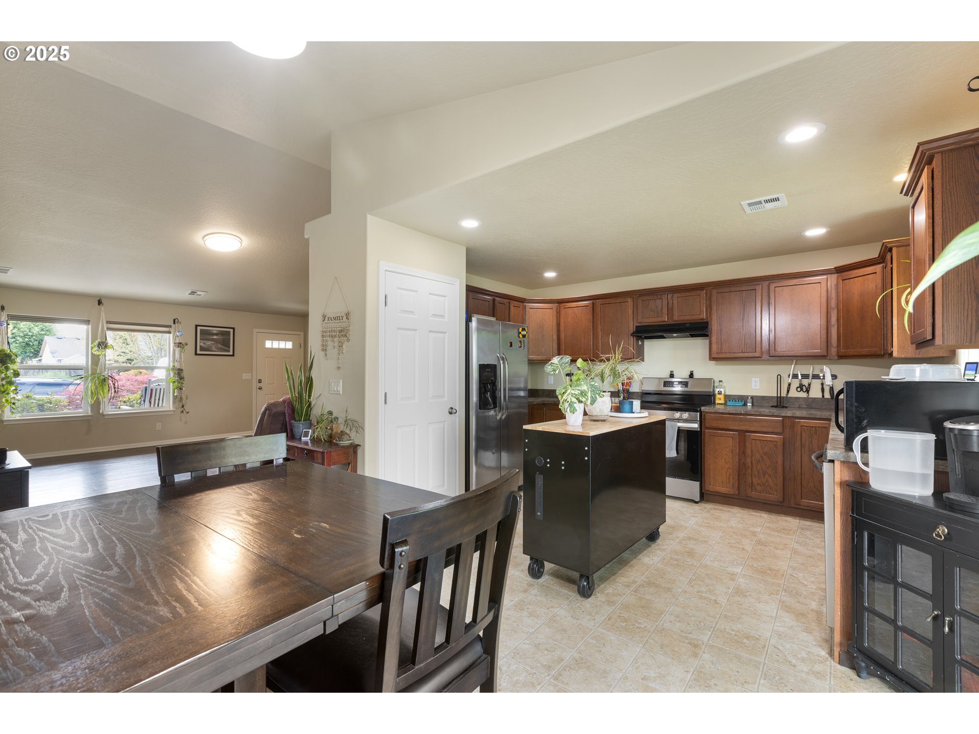335 Gentry Loop Myrtle Creek, OR 97457 - Photo 11 of 41 a kitchen with stainless steel appliances kitchen island granite countertop a refrigerator a stove a sink dishwasher with a dining table and chairs with wooden floor