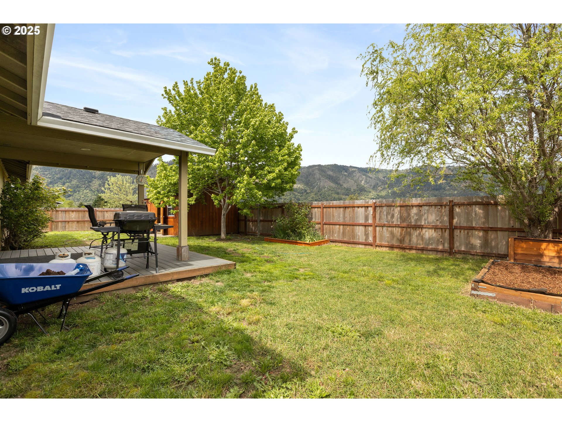 335 Gentry Loop Myrtle Creek, OR 97457 - Photo 37 of 41 a view of a backyard with table and chairs under an umbrella
