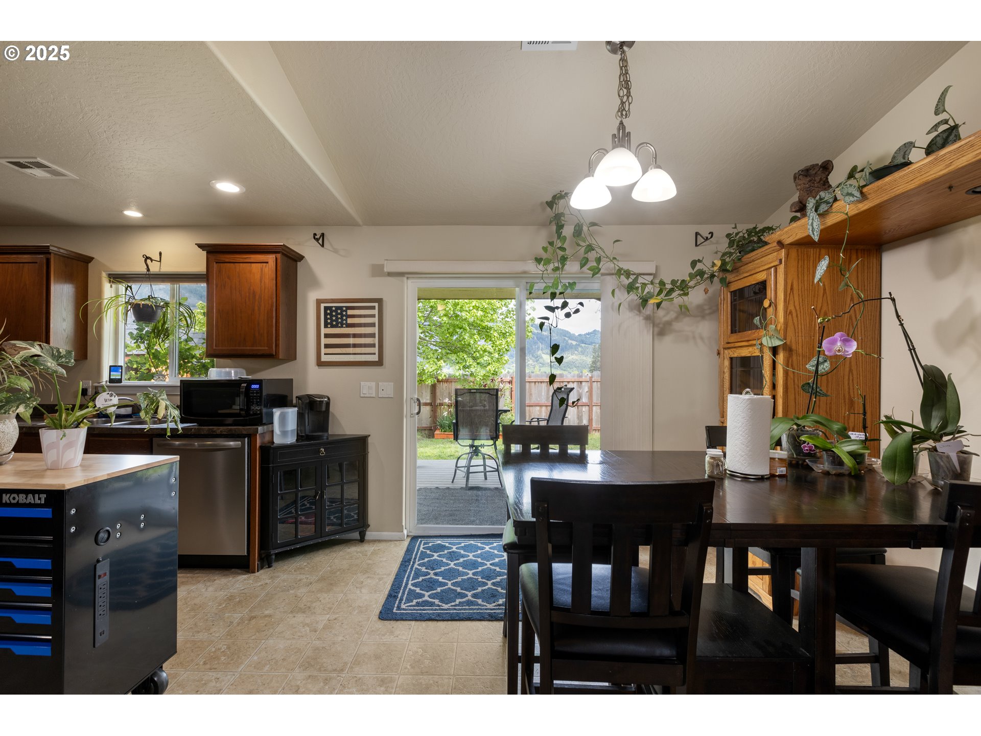 335 Gentry Loop Myrtle Creek, OR 97457 - Photo 9 of 41 a dining room with wooden floor a chandelier a wooden table and chairs