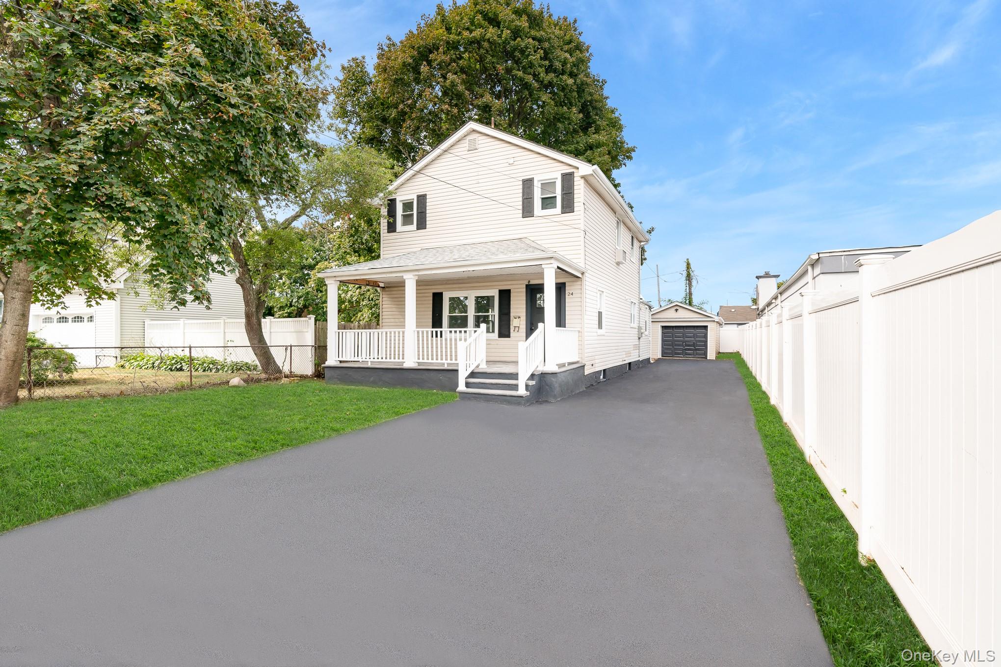 24 Calvert Avenue West Babylon, NY 11704 - Photo 1 of 28 View of front of house with an outdoor structure, a porch, a detached garage, a front lawn, and driveway