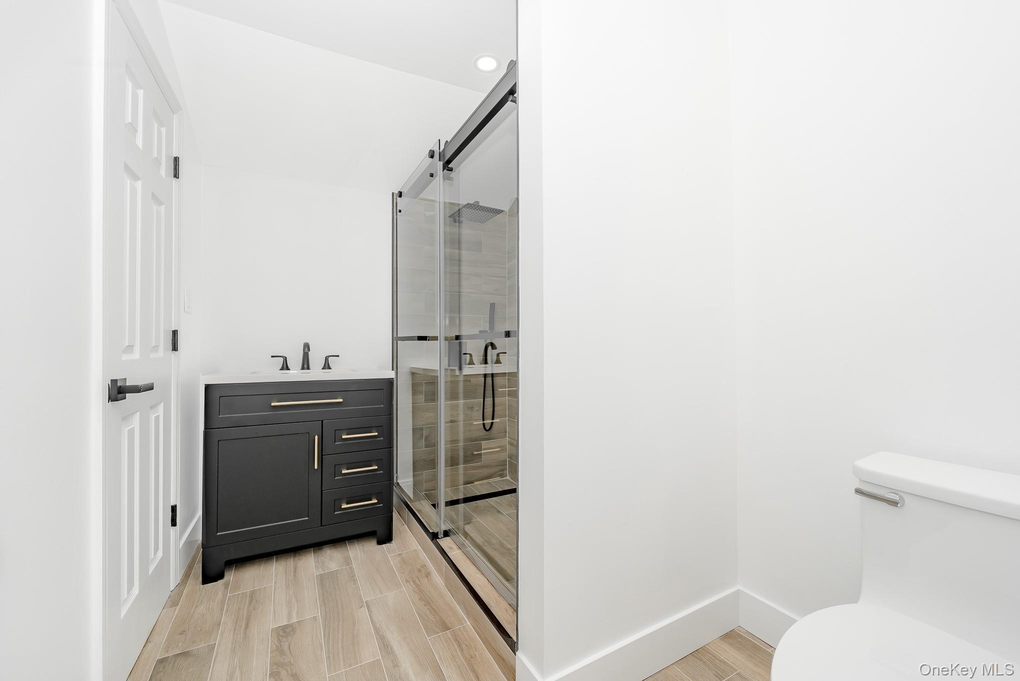 24 Calvert Avenue West Babylon, NY 11704 - Photo 15 of 28 Bathroom with vanity, a shower stall, and wood tiled floors