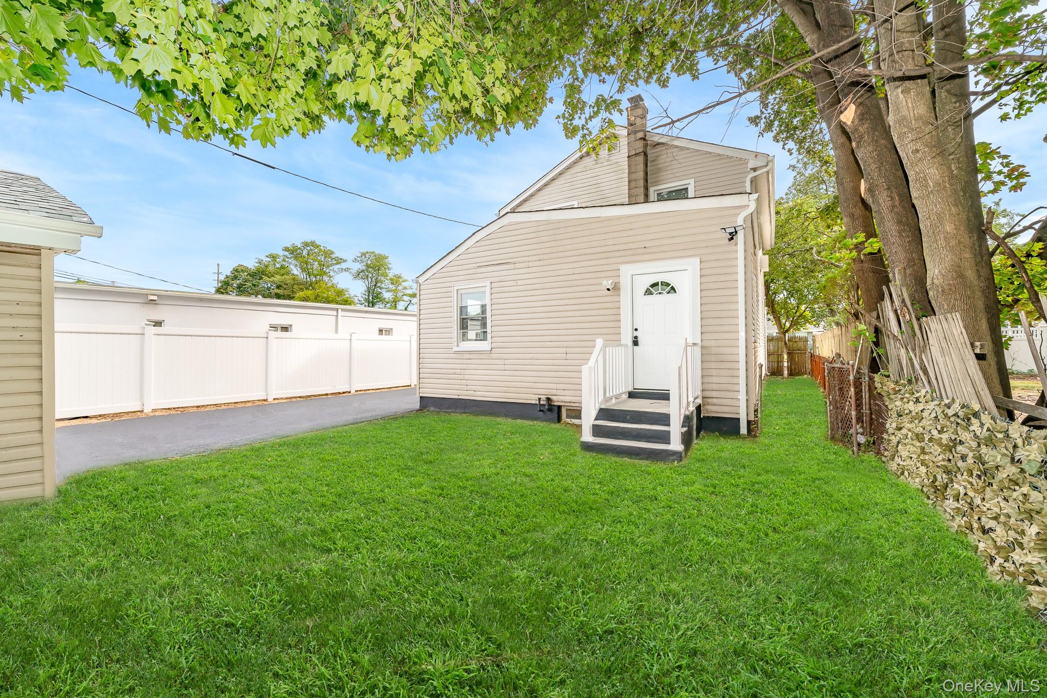 24 Calvert Avenue West Babylon, NY 11704 - Photo 22 of 28 Rear view of property featuring a fenced backyard and a chimney