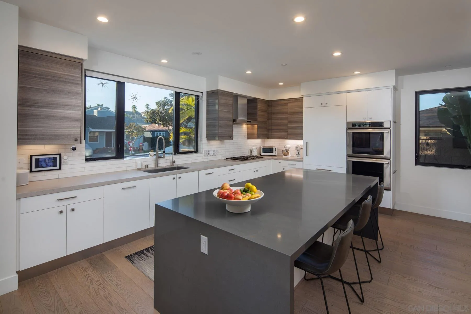 307 La Mesa Avenue Encinitas, CA 92024 - Photo 5 of 33 a kitchen with stainless steel appliances granite countertop a sink a stove a dining table and chairs with wooden floor