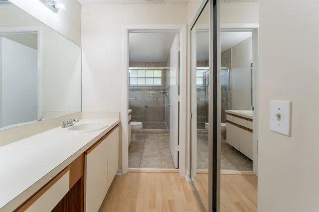 a bathroom with a double vanity sink mirror and shower