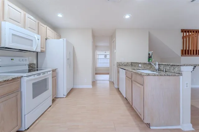 a kitchen with stainless steel appliances granite countertop a refrigerator and a stove