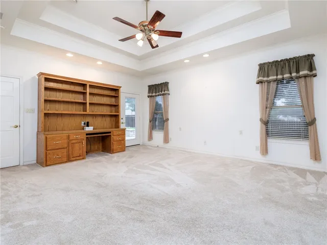 an empty room with closet and a ceiling fan