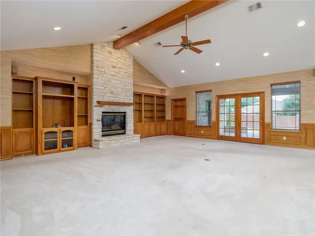 an empty room with balcony and fireplace