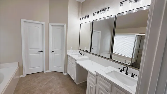 a bathroom with a tub sink and mirror