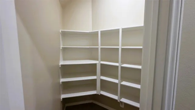 an empty room with wooden floor ceiling fan and windows