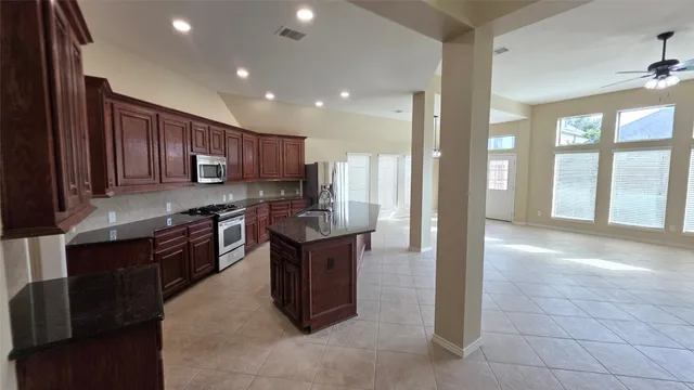 a view of a kitchen with a sink and an empty room