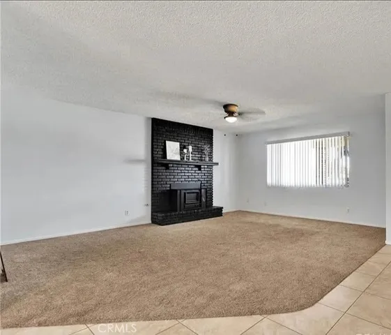 a view of an empty room with a fireplace and a window