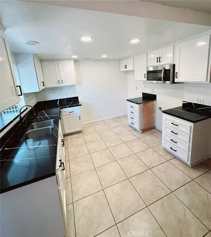 a kitchen with stainless steel appliances a sink a stove a microwave and cabinets