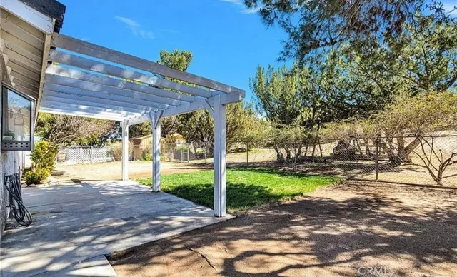 a view of a backyard with table and chairs and a large tree
