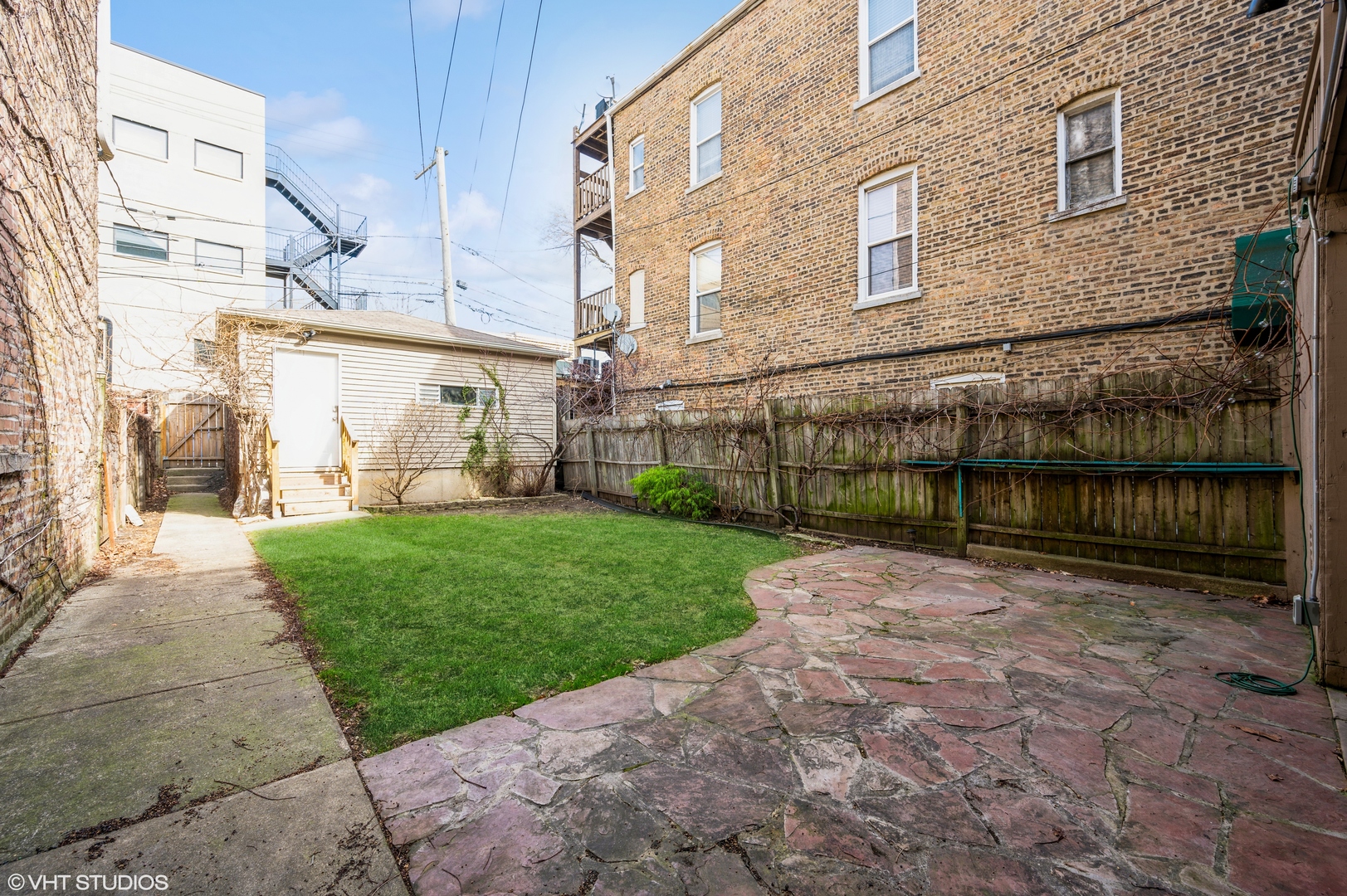 2116 West Lyndale Street, Unit 1 Chicago, IL 60647 - Photo 14 of 16 a view of a backyard with brick wall and potted plants