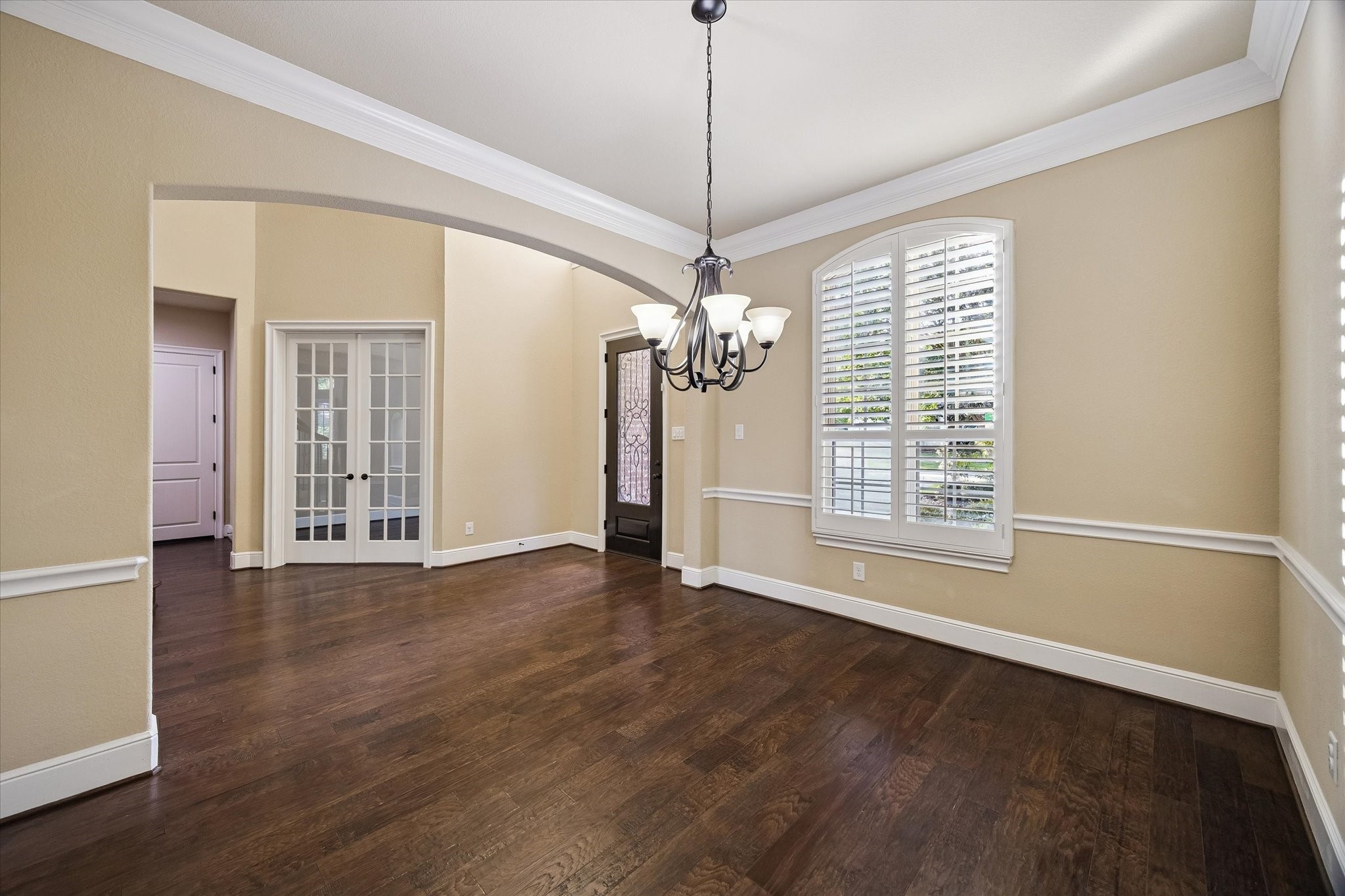 35 North Fremont Ridge Loop Spring, TX 77389 - Photo 5 of 37 Designed for memorable gatherings, the formal dining room showcases rich hardwood floors, elegant crown molding, plantation shutters, and a warm, welcoming ambiance filled with natural light.