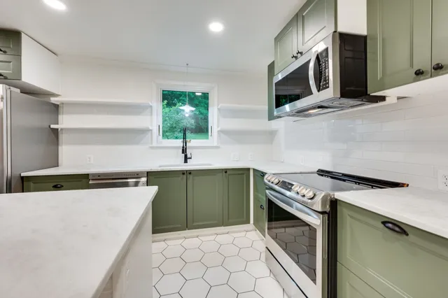 a kitchen with stainless steel appliances granite countertop a sink stove and microwave