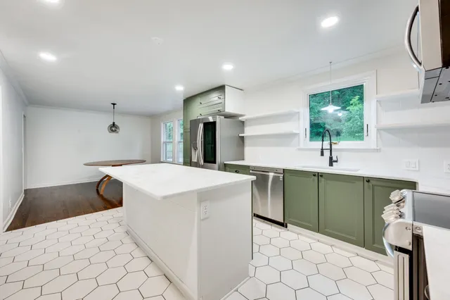 a kitchen with a sink cabinets and wooden floor