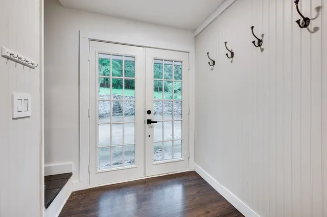 a view of an empty room with wooden floor and windows