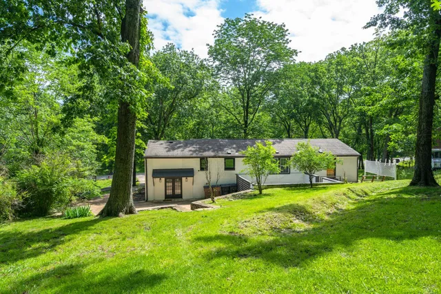 a view of a house with a yard and sitting area