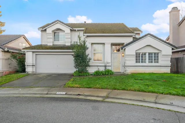 a front view of a house with a garden and yard