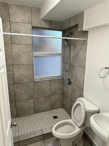 a bathroom with a toilet a sink and shower