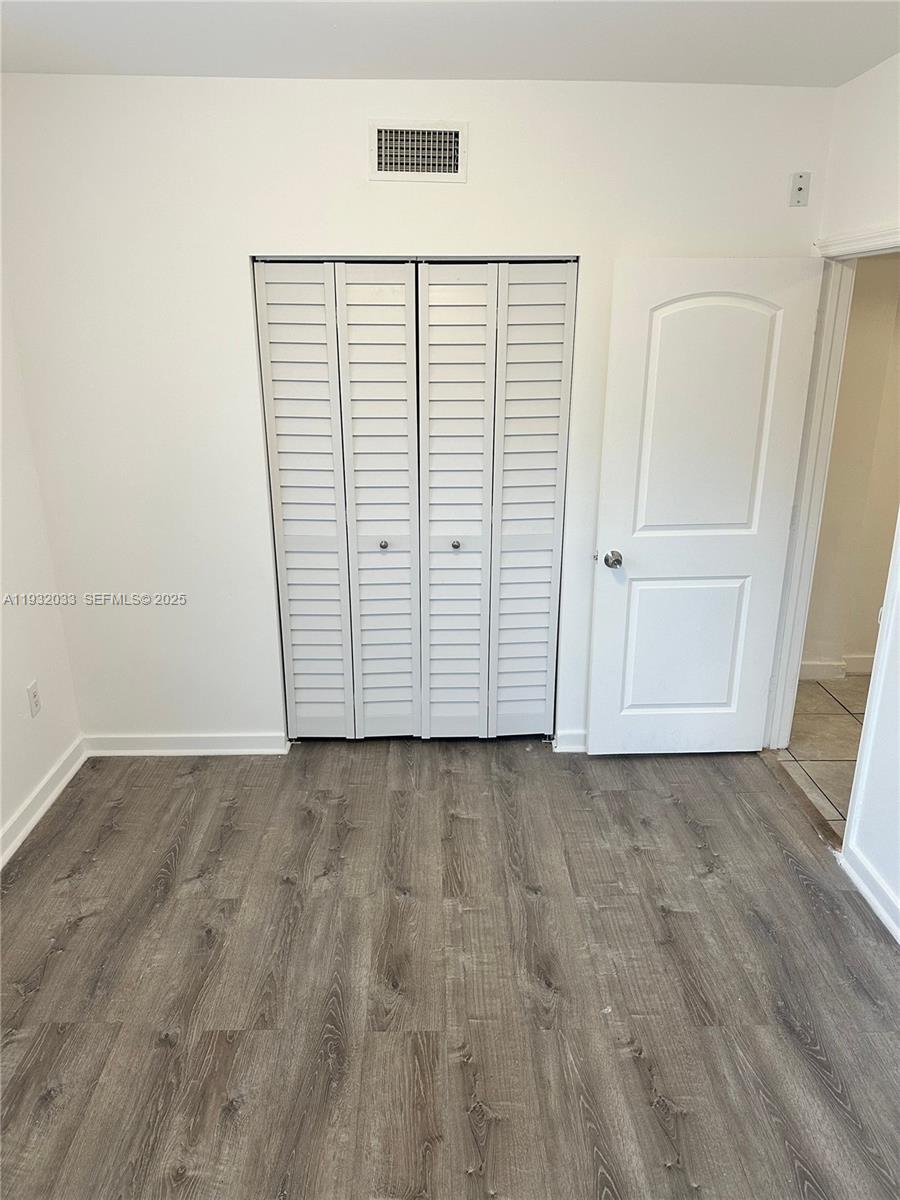 1129 Northwest 3rd Street, Unit 202 Miami, FL 33128 - Photo 10 of 10 an empty room with wooden floor