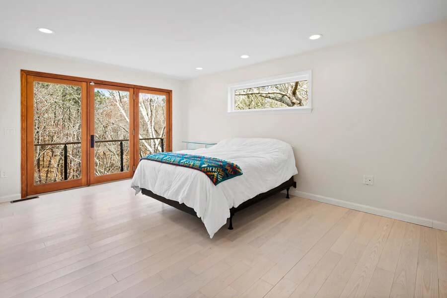 135 Old Truro Road Wellfleet, MA 02667 - Photo 22 of 38 a spacious bedroom with a large bed and a large window