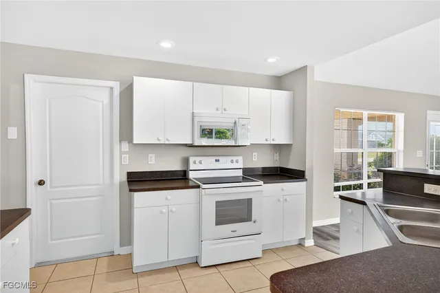 a kitchen with white cabinets and white appliances