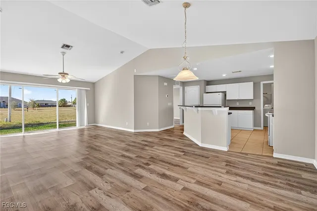 a view of a kitchen with a refrigerator and a floor to ceiling window