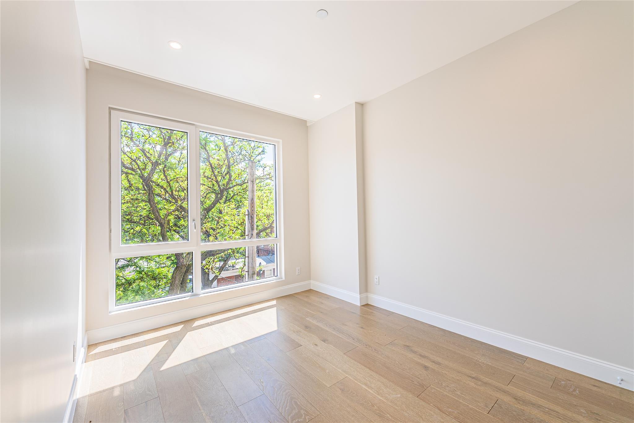 42-09 Hampton Street, Unit 4B Queens, NY 11373 - Photo 6 of 16 an empty room with wooden floor and windows