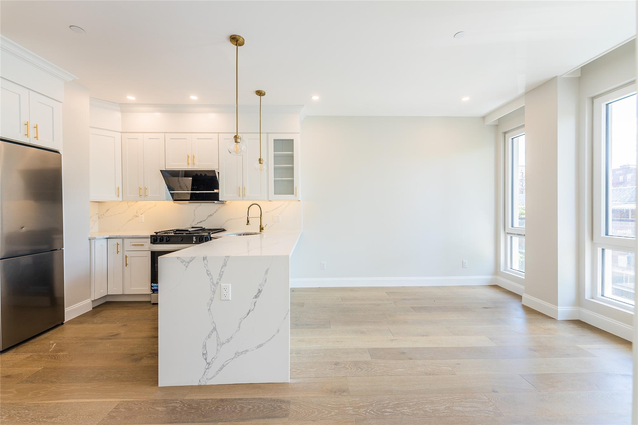 42-09 Hampton Street, Unit 4B Queens, NY 11373 - Photo 8 of 16 a kitchen with kitchen island a counter top space a sink stainless steel appliances and cabinets