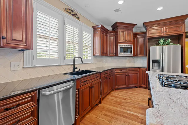 a kitchen with stainless steel appliances granite countertop a sink stove and cabinets