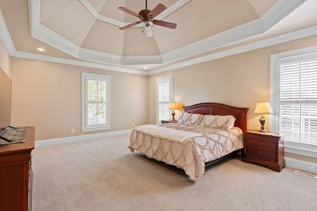 a bedroom with a bed lamp and a large window