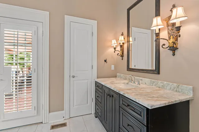 a bathroom with a granite countertop sink and a mirror