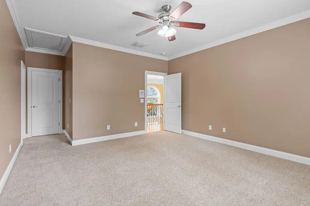 a view of an empty room with chandelier fan
