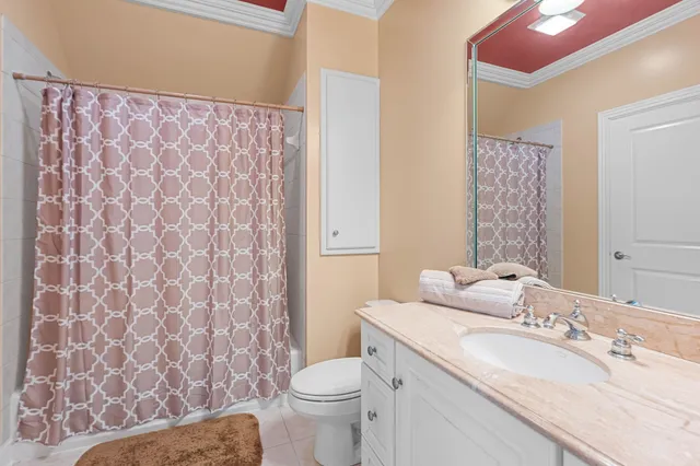 a bathroom with a granite countertop toilet sink and mirror