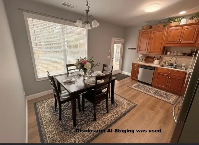 a kitchen with granite countertop a stove a sink a dining table and chairs with wooden floor