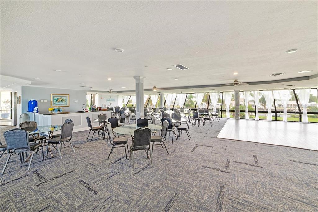 5915 Sea Ranch Drive, Unit 211 Hudson, FL 34667 - Photo 22 of 26 a room with lots of tables a large window and chairs